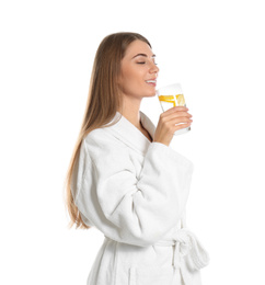 Young woman drinking lemon water on white background