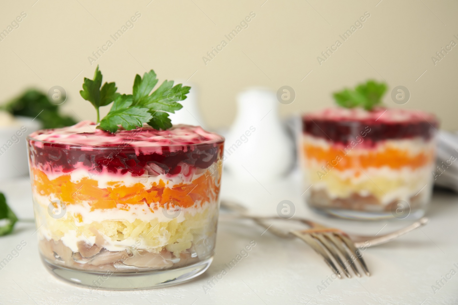 Photo of Herring under fur coat served on white table, space  for text. Traditional russian salad