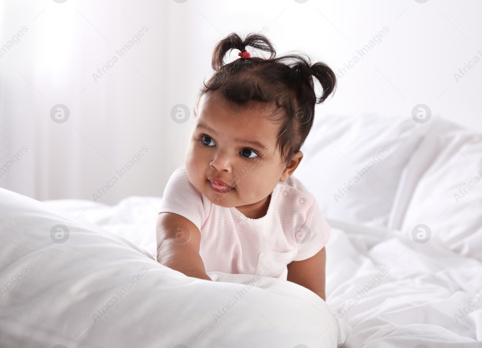 Photo of Cute African American baby on bed at home