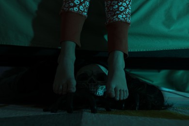 Photo of Childhood phobia. Girl and scary monster under bed at home, closeup