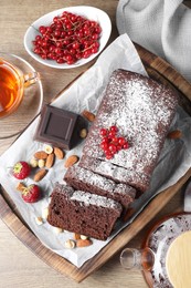 Photo of Tasty chocolate sponge cake served on wooden table, flat lay