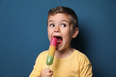 Photo of Adorable little boy with delicious ice cream against color background