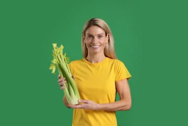 Photo of Happy woman with fresh celery bunch on green background