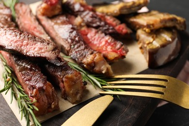 Photo of Delicious grilled beef with rosemary served on table, closeup