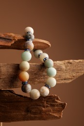 Photo of Stylish presentation of beautiful bracelet with gemstones on brown background