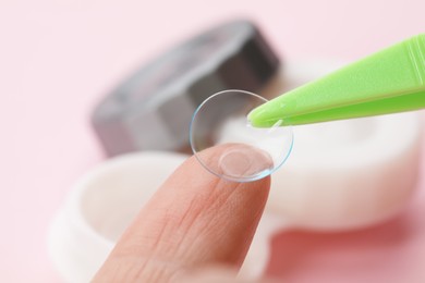 Photo of Woman with contact lens and tweezers on blurred background, closeup