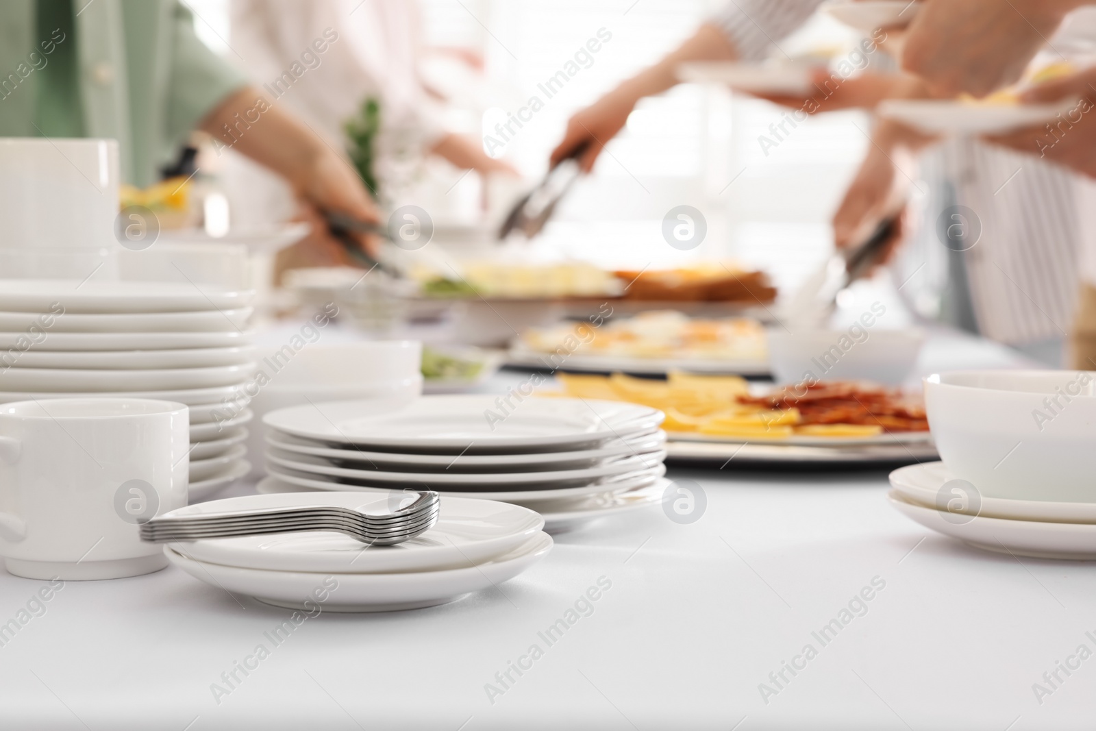 Photo of People taking food during breakfast, focus on clean dishware. Buffet service