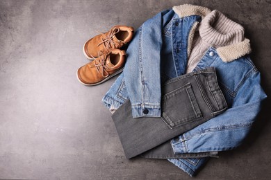 Photo of Warm child clothes and shoes on grey background, flat lay. Space for text