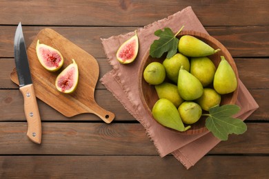 Cut and whole green figs with knife on wooden table, flat lay