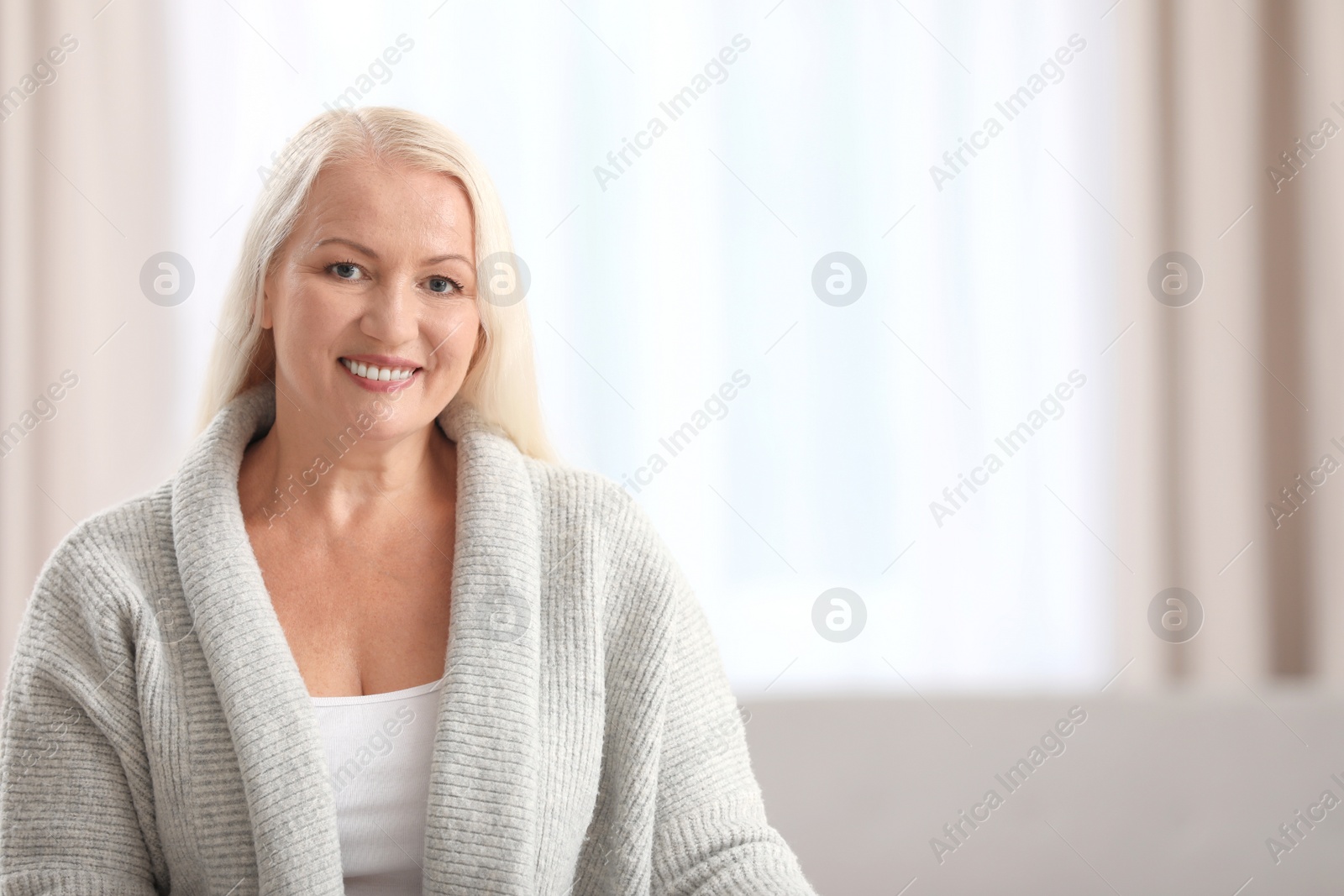 Photo of Portrait of beautiful older woman against blurred background with space for text