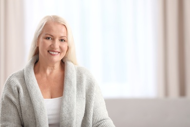 Portrait of beautiful older woman against blurred background with space for text