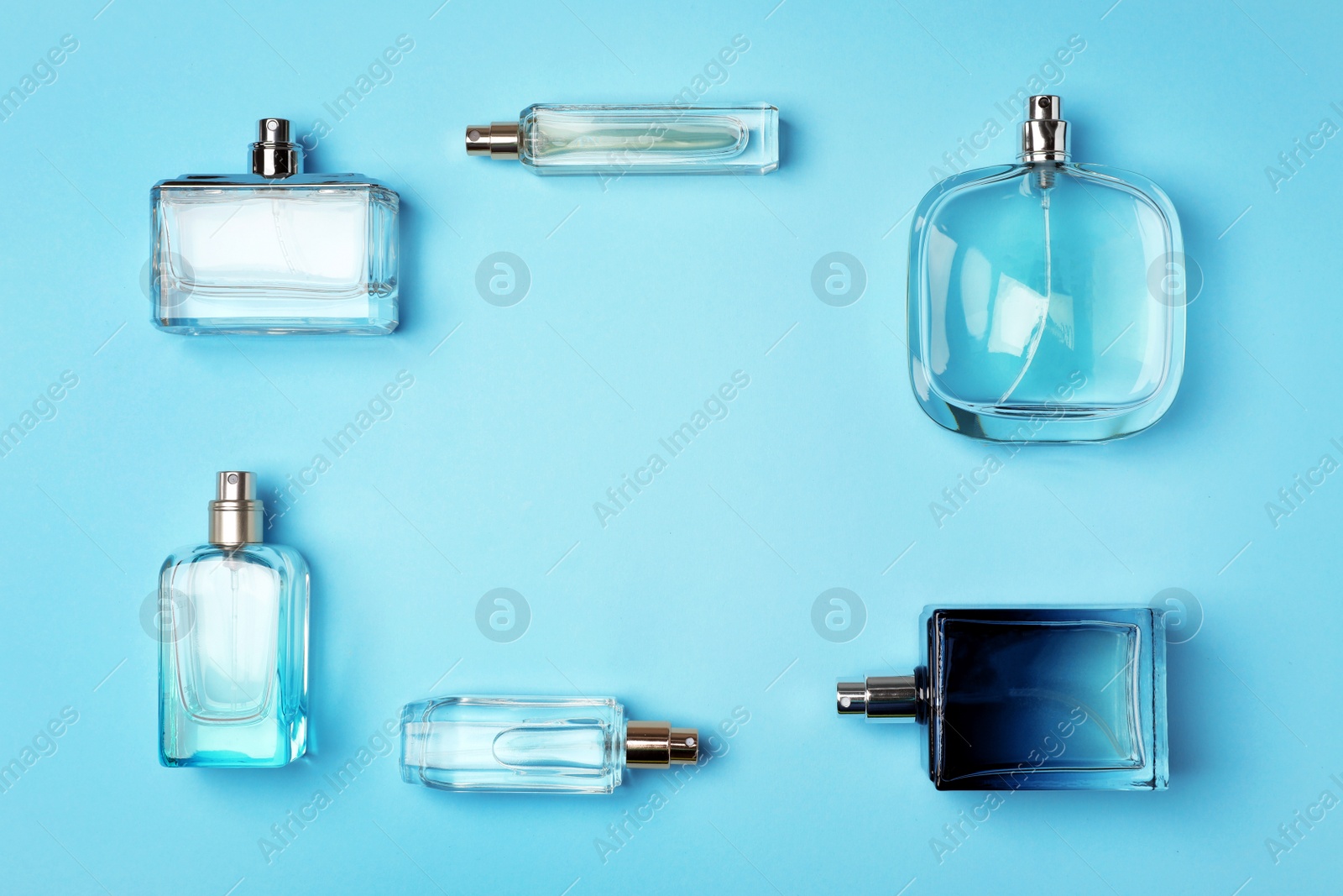 Photo of Flat lay composition with bottles of perfume on color background