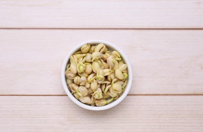 Photo of Sprouted kidney beans in bowl on white wooden table, top view