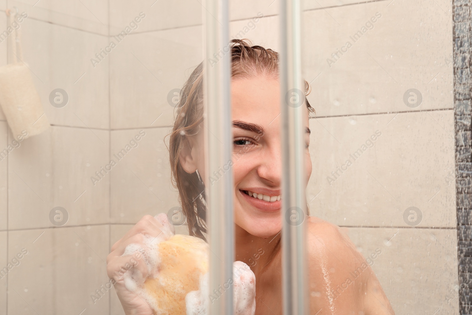 Photo of Beautiful young woman taking shower at home