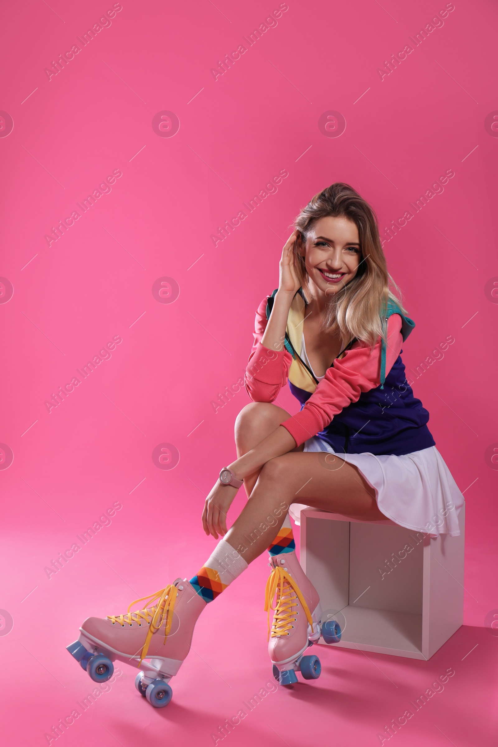 Photo of Young woman with retro roller skates on color background