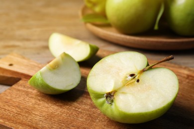 Photo of Cut fresh green apple on wooden table, closeup