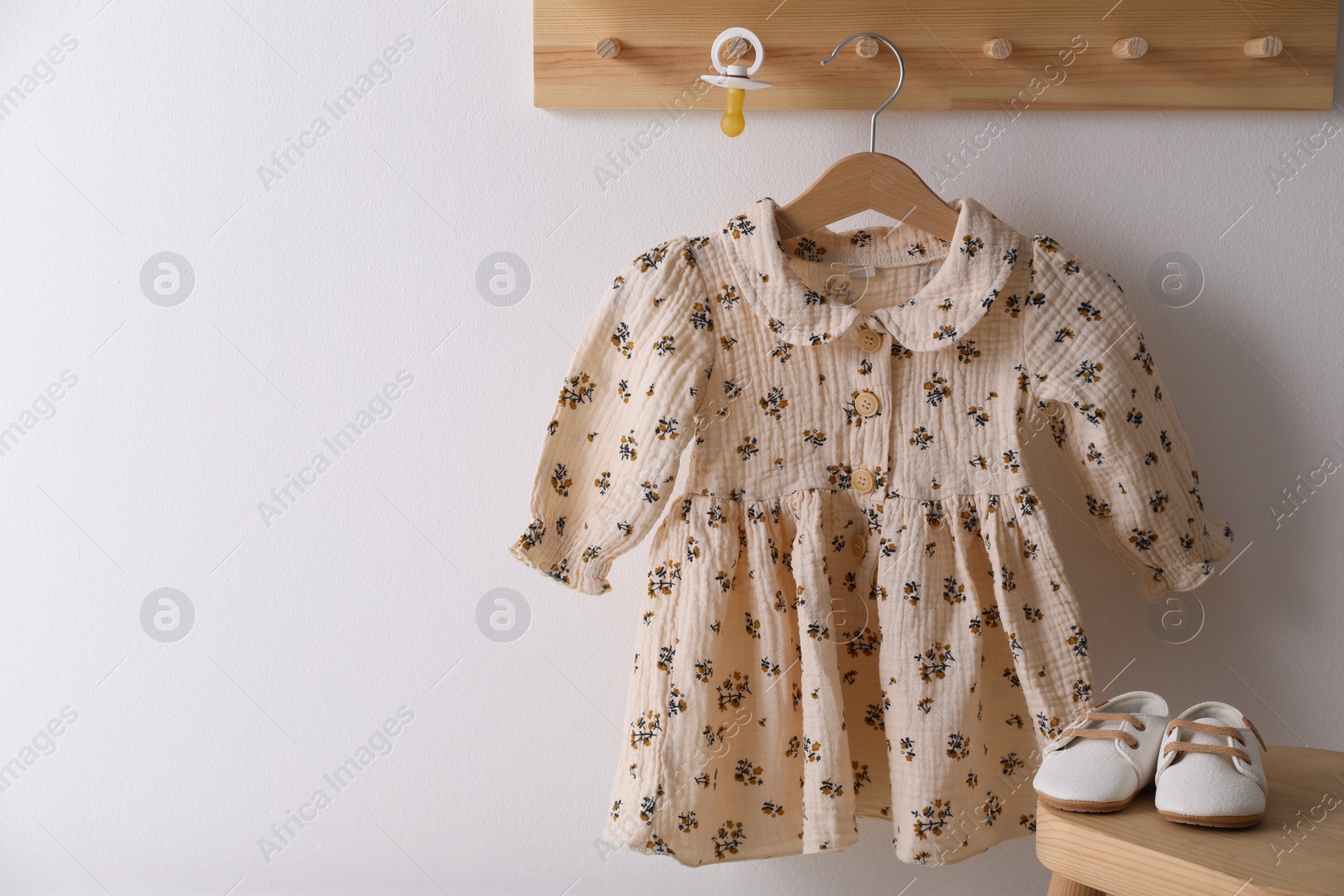 Photo of Cute children's dress and shoes in room. Space for text