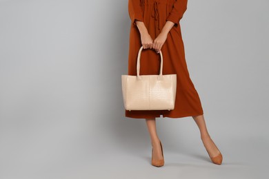 Photo of Woman with stylish bag on grey background, closeup