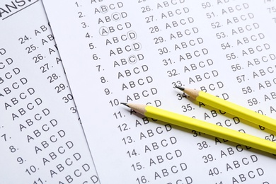 Yellow pencils on answer sheets, closeup view