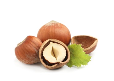 Tasty organic hazelnuts and leaf on white background