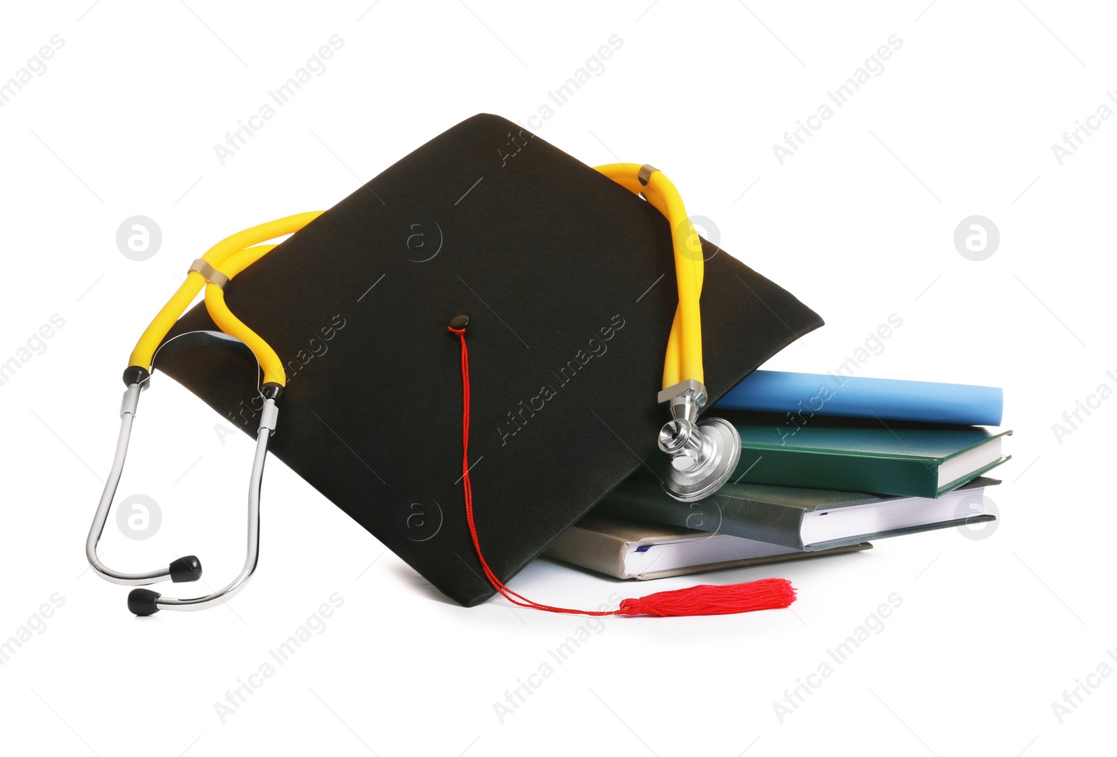 Photo of Stack of student textbooks, graduation hat and stethoscope on white background. Medical education