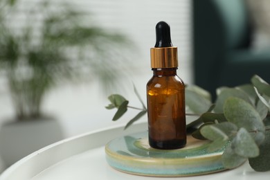 Photo of Aromatherapy. Bottle of essential oil and eucalyptus leaves on table, space for text