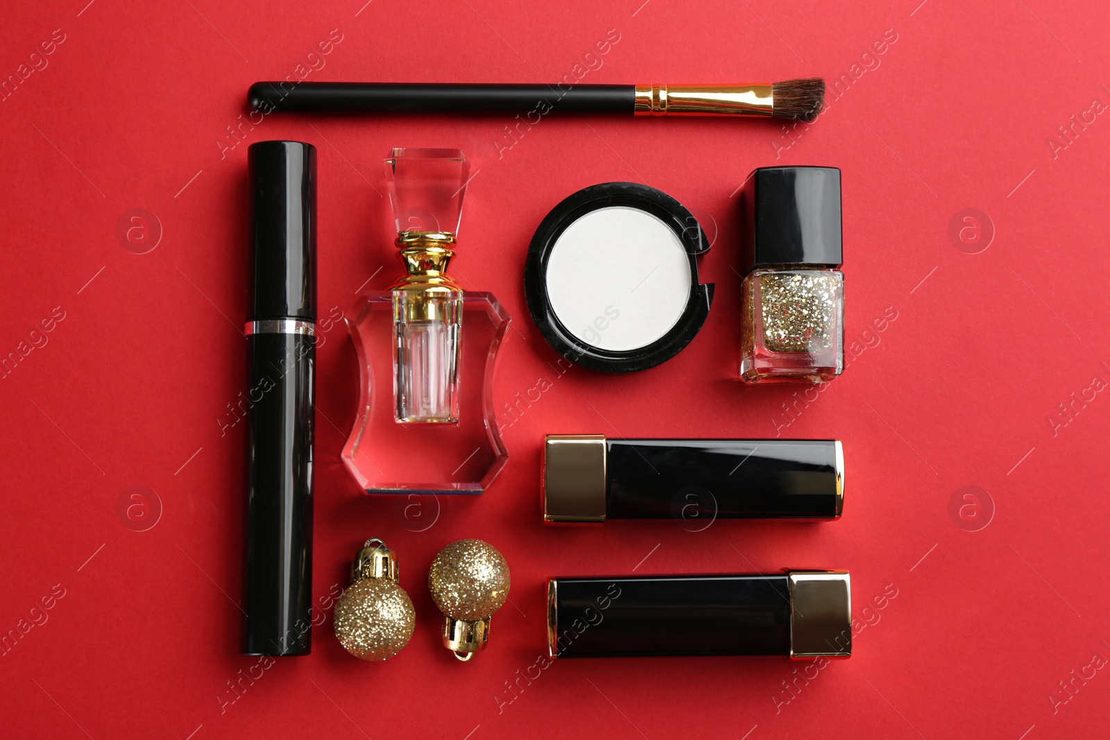 Photo of Flat lay composition with decorative cosmetic products on red background. Winter care