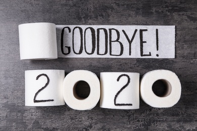 Photo of Text Goodbye 2020 made with toilet paper on grey stone background, flat lay