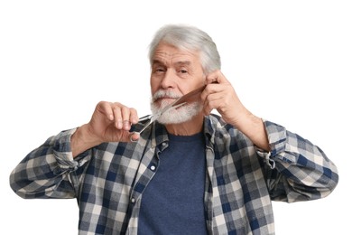 Senior man trimming beard with scissors on white background