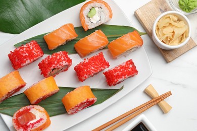 Photo of Flat lay composition with delicious sushi rolls on white marble table