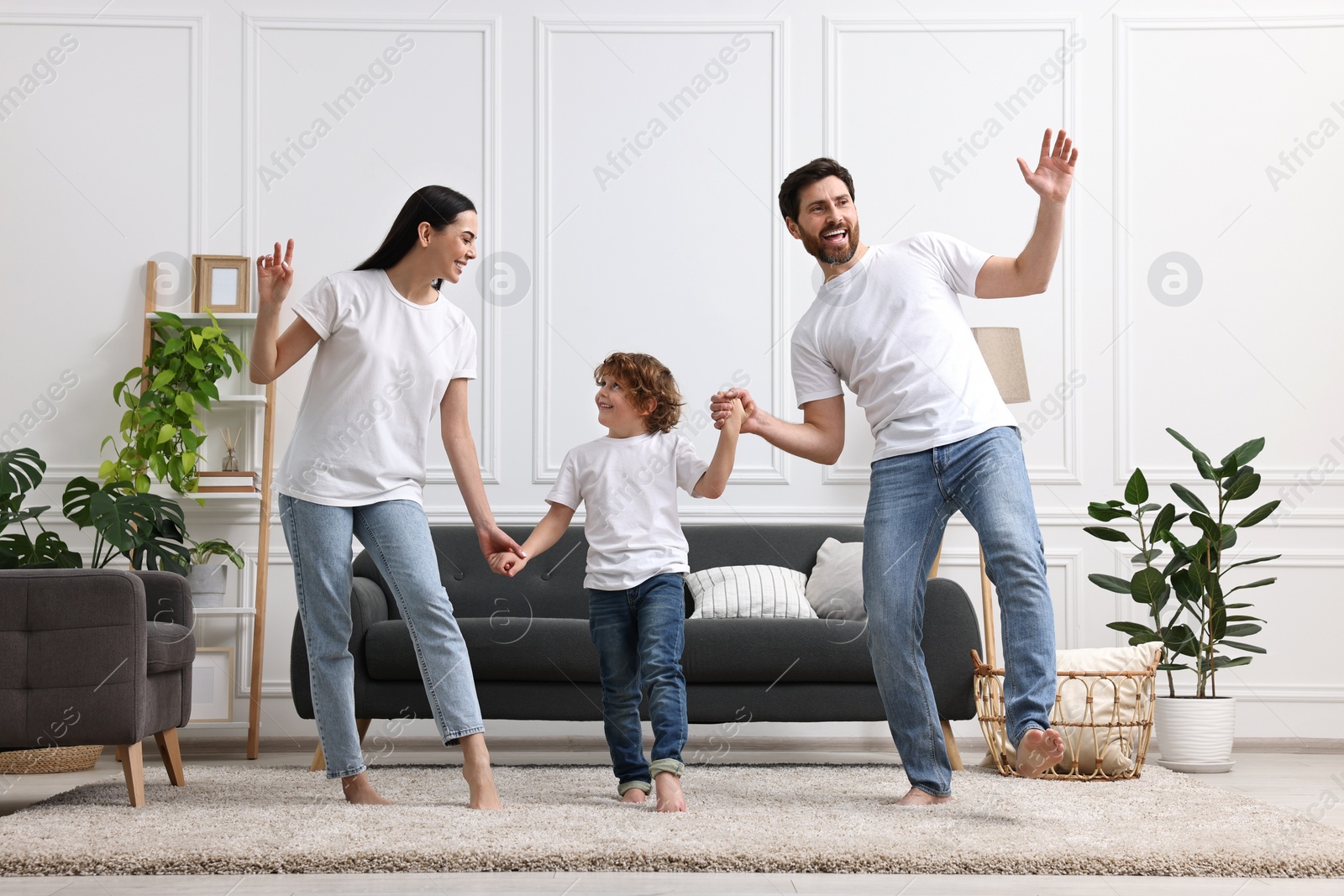 Photo of Happy family dancing and having fun in living room