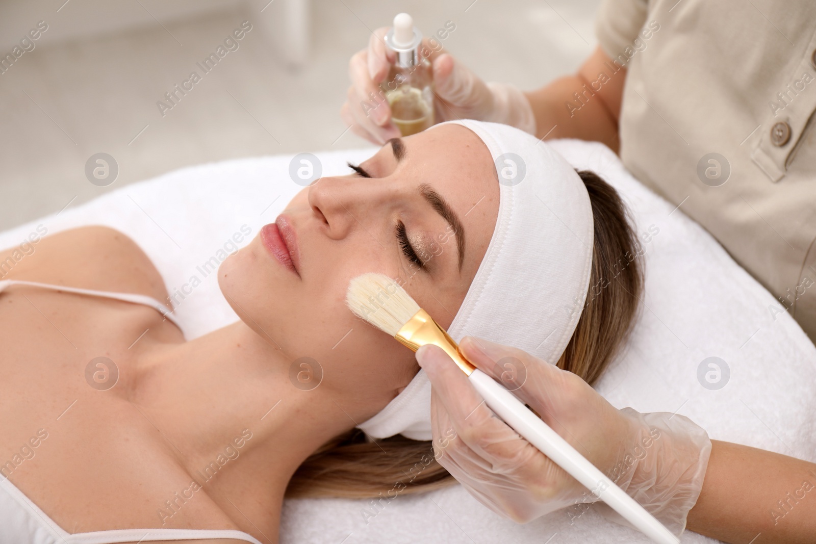 Photo of Young woman during face peeling procedure in salon