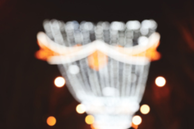 Photo of Blurred view of city street with festive lights at night. Bokeh effect