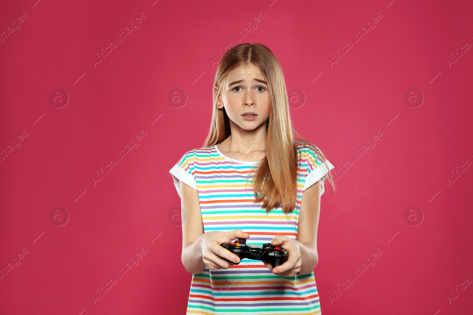 Photo of Teenage girl playing video games with controller on color background