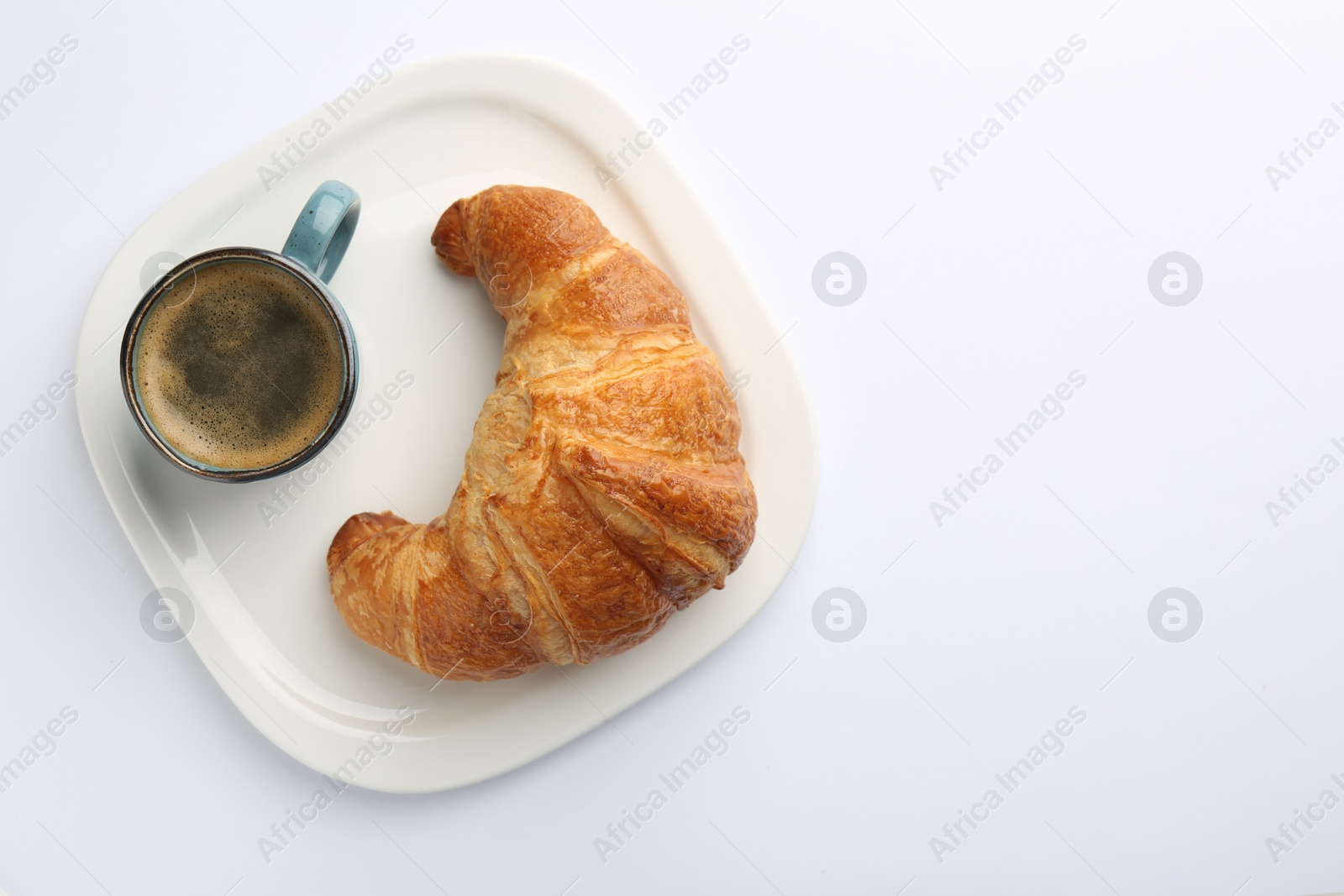 Photo of Delicious fresh croissant and cup of coffee on white background, top view. Space for text