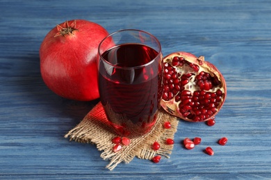 Photo of Glass of pomegranate juice and fresh fruits on wooden background