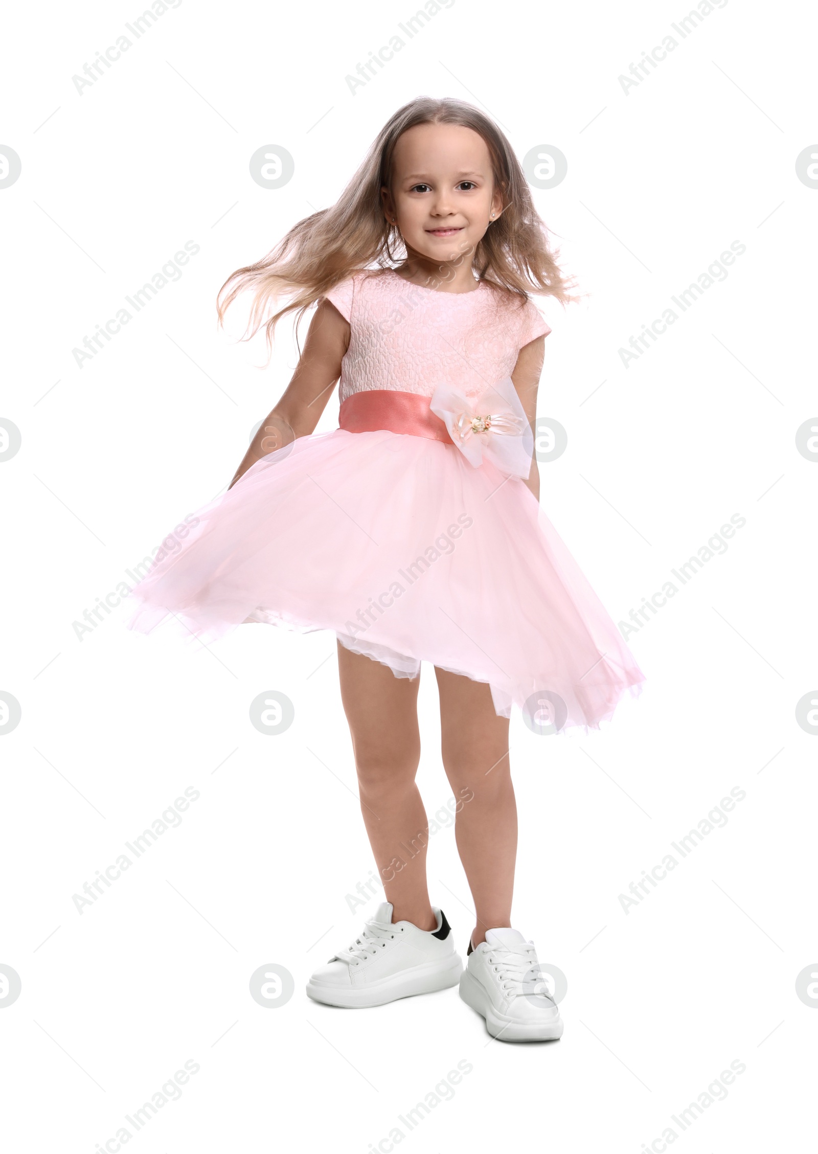 Photo of Cute little girl in beautiful dress dancing on white background