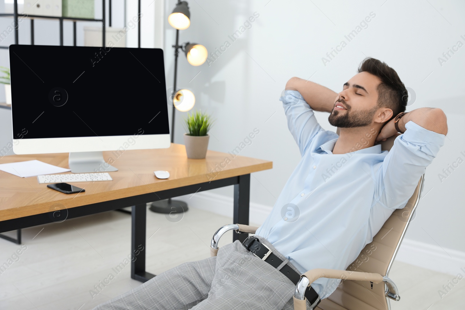 Photo of Young businessman relaxing in office chair at workplace