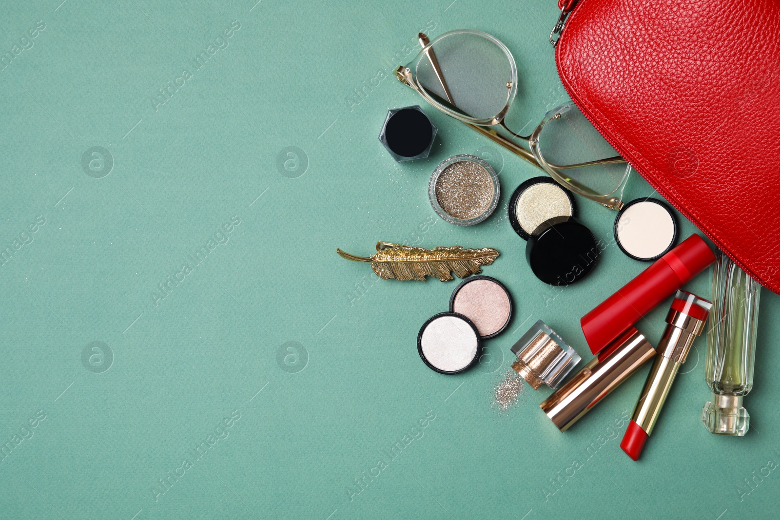 Photo of Cosmetic bag with makeup products and beauty accessories on gray-green background, flat lay. Space for text