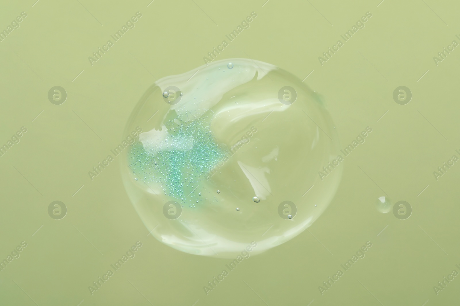 Photo of Sample of cleansing gel on light green background, top view. Cosmetic product