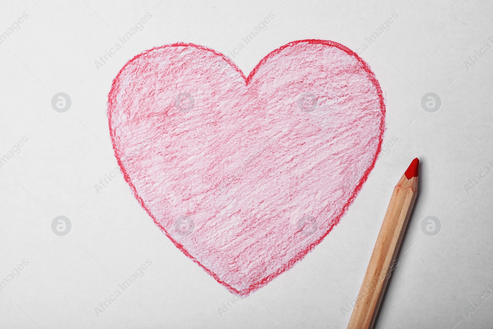 Photo of Drawn heart and pencil on sheet of paper, top view