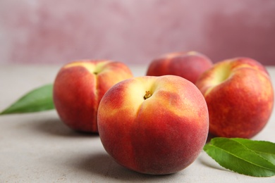 Photo of Fresh juicy peaches and leaves on light table