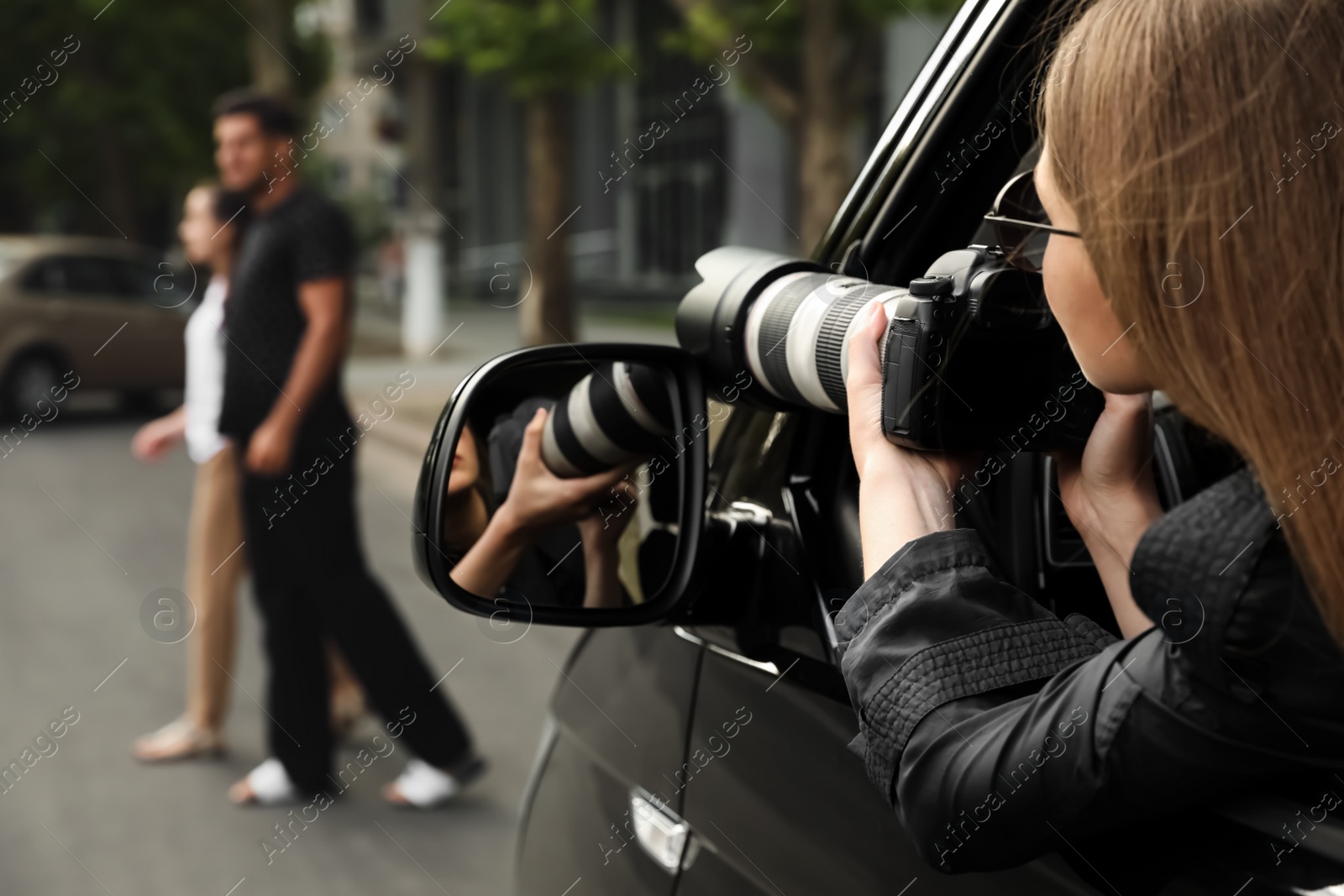 Photo of Private detective with camera spying from car