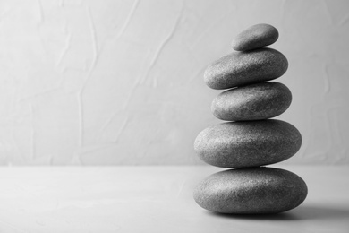 Photo of Stack of zen stones on table against light background. Space for text