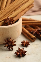 Photo of Bowl with cinnamon sticks and star anise on light table, closeup