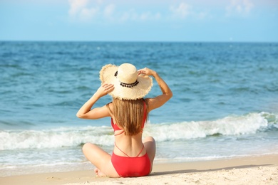 Photo of Attractive young woman in beautiful one-piece swimsuit on beach