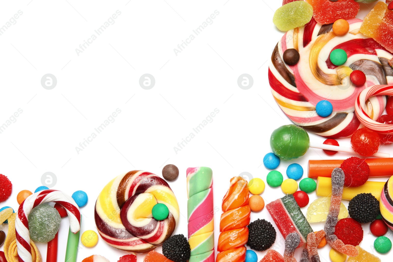 Photo of Many different yummy candies on white background, top view. Space for text