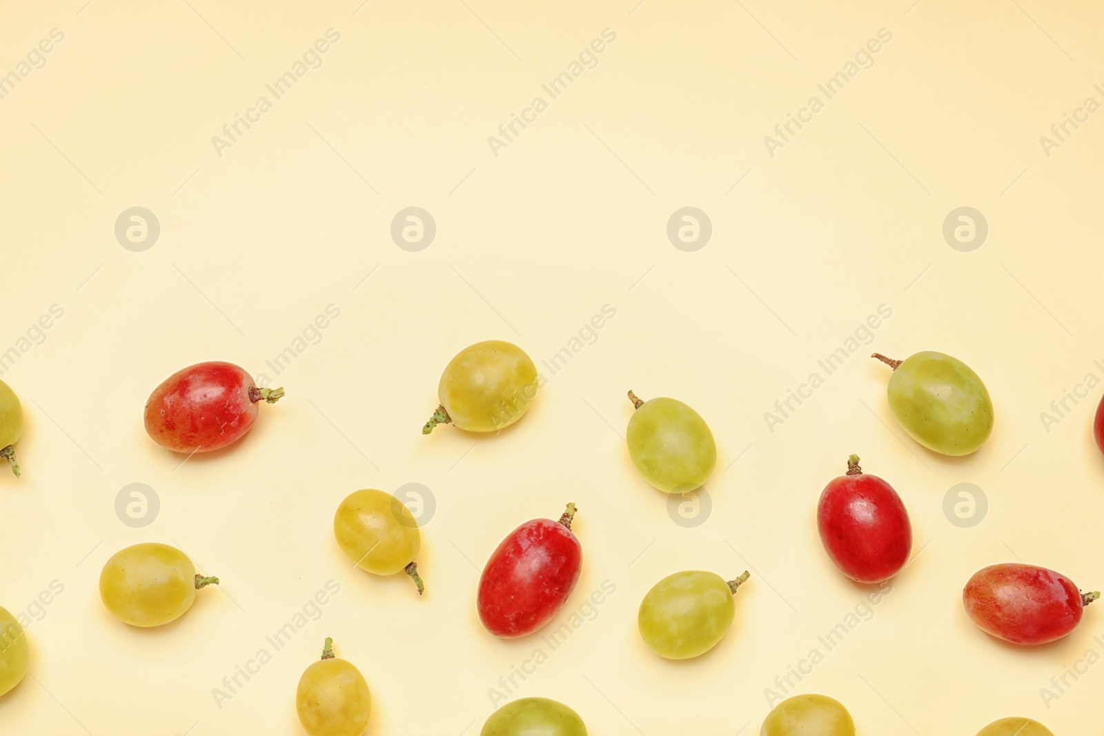 Photo of Fresh ripe juicy grapes on color background, top view. Space for text