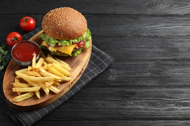 Photo of Delicious burger with beef patty, tomato sauce and french fries on black wooden table, above view. Space for text