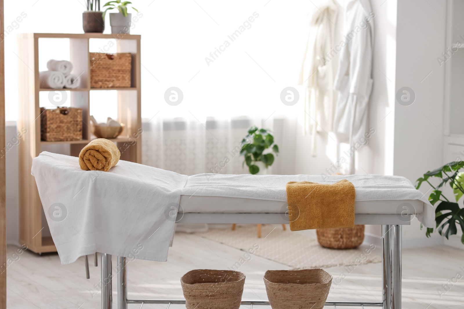 Photo of Comfortable massage table with clean towels in spa center